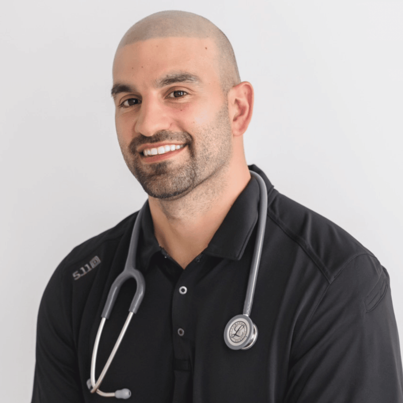 Man wearing a black shirt with a stethoscope around his neck on a white background. Josh Himes Founder and Dr. of Functional Medicine. Pro Health Place. 