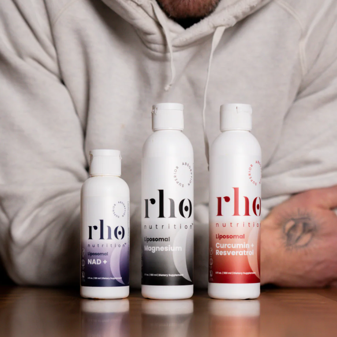 Three bottles of rho nutrition products on a table with a person wearing a gray hoodie in the background.